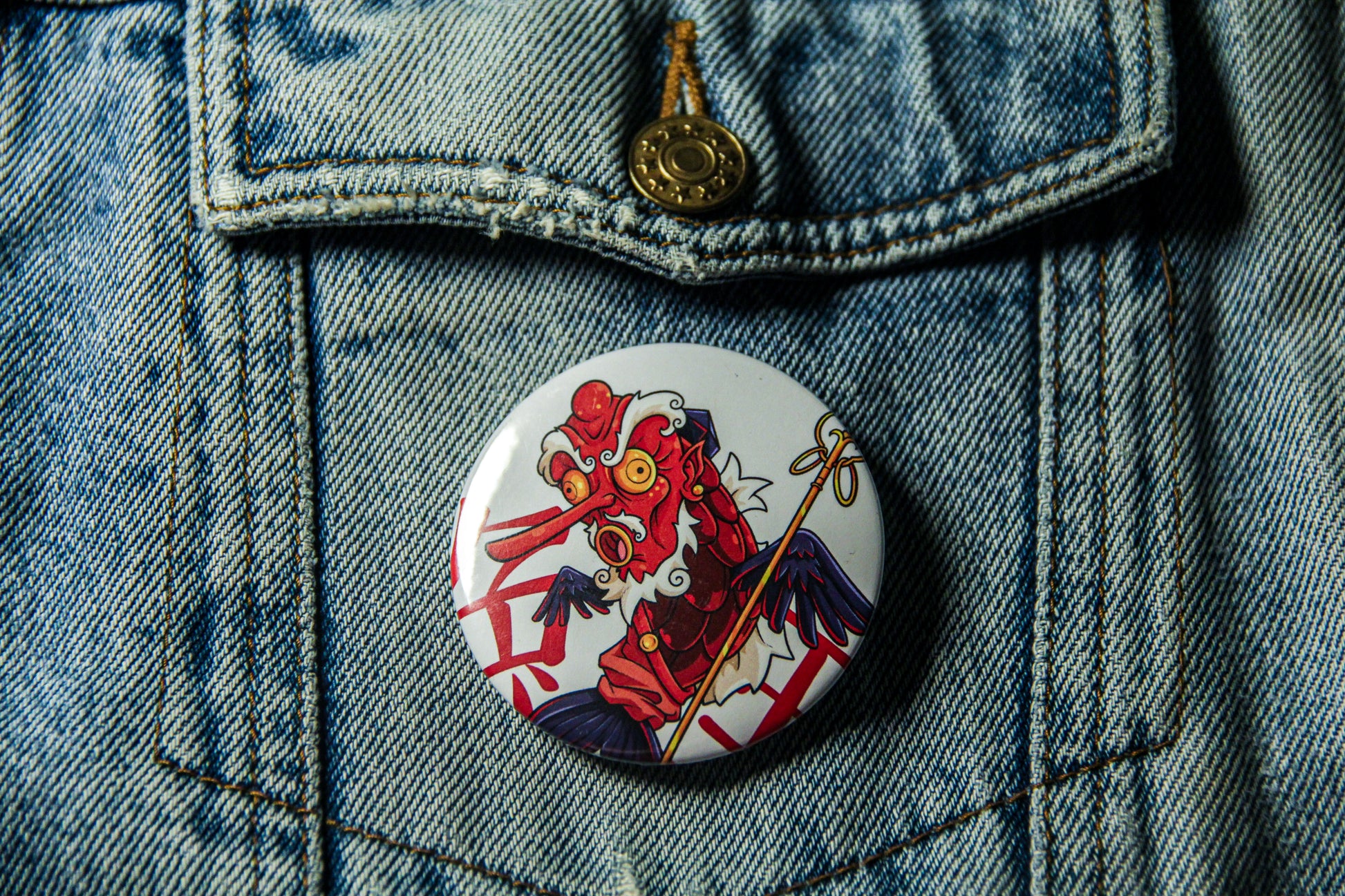 Pin's de 58mm sur une veste en jean. Carpe Tengu Rouge.