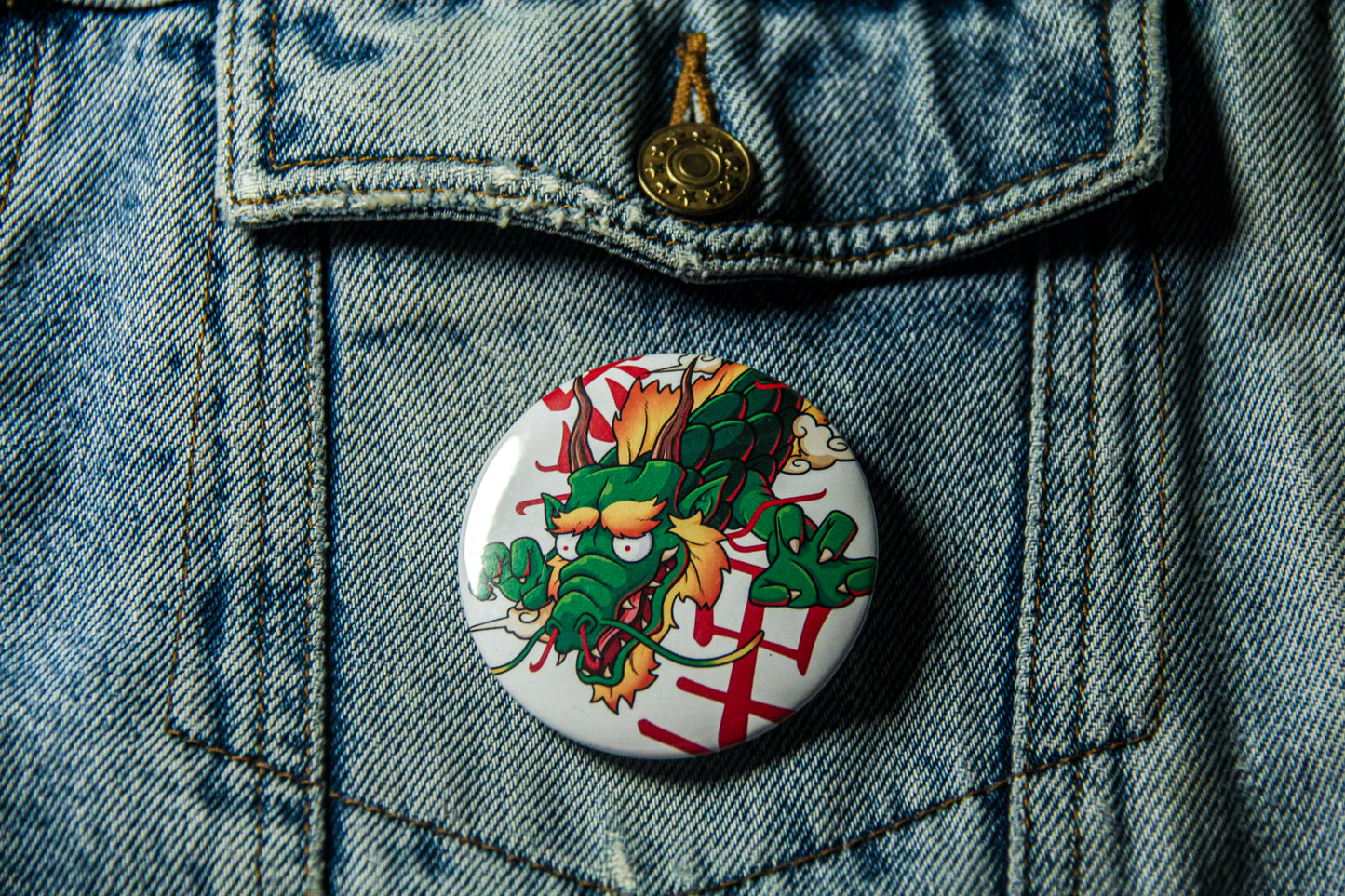 Pin's de carpe Dragon sur une veste en jean. Fabrication artisanale.