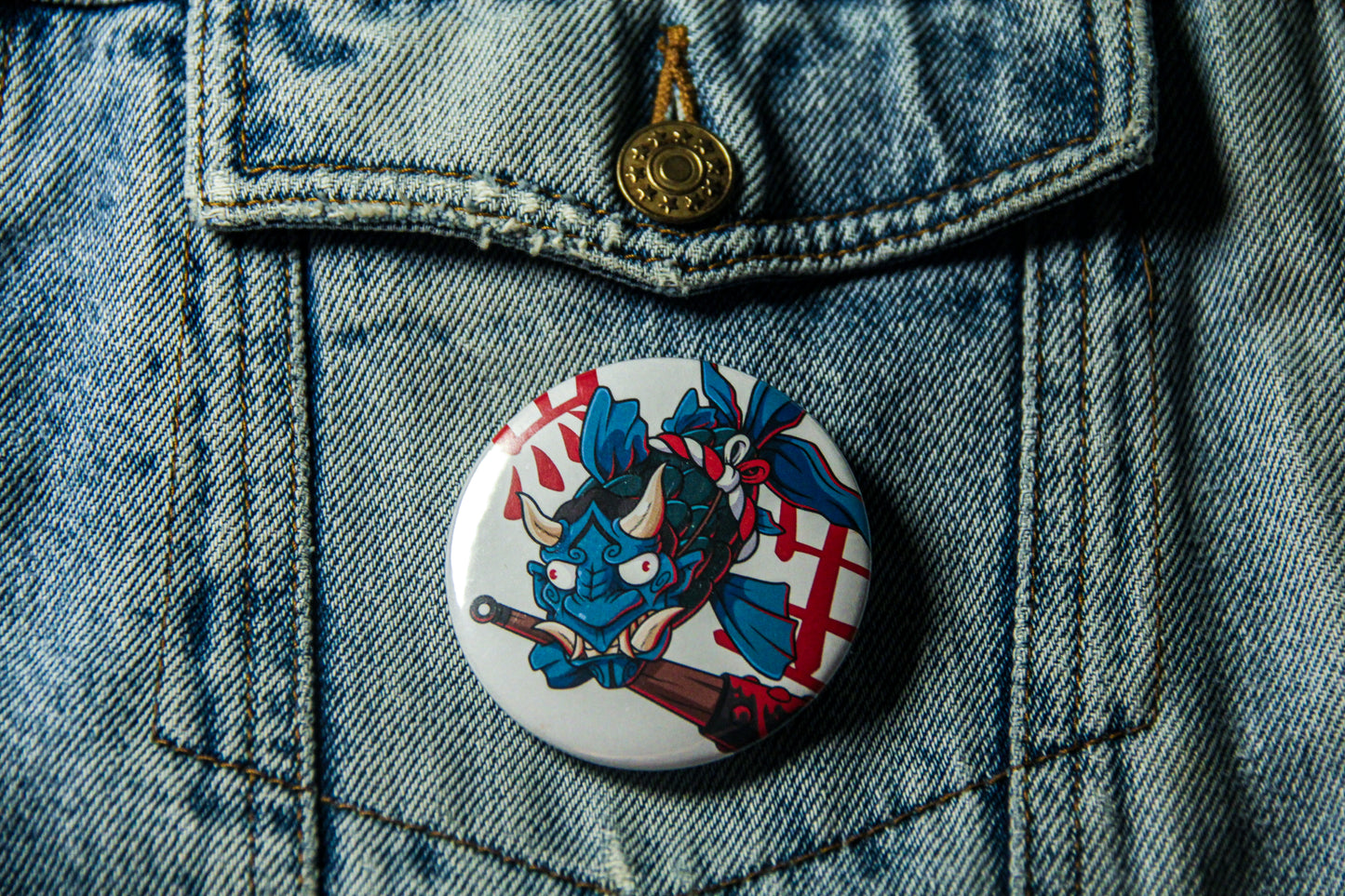 Pin's de carpe Oni sur une veste en jean. Fabrication artisanale.