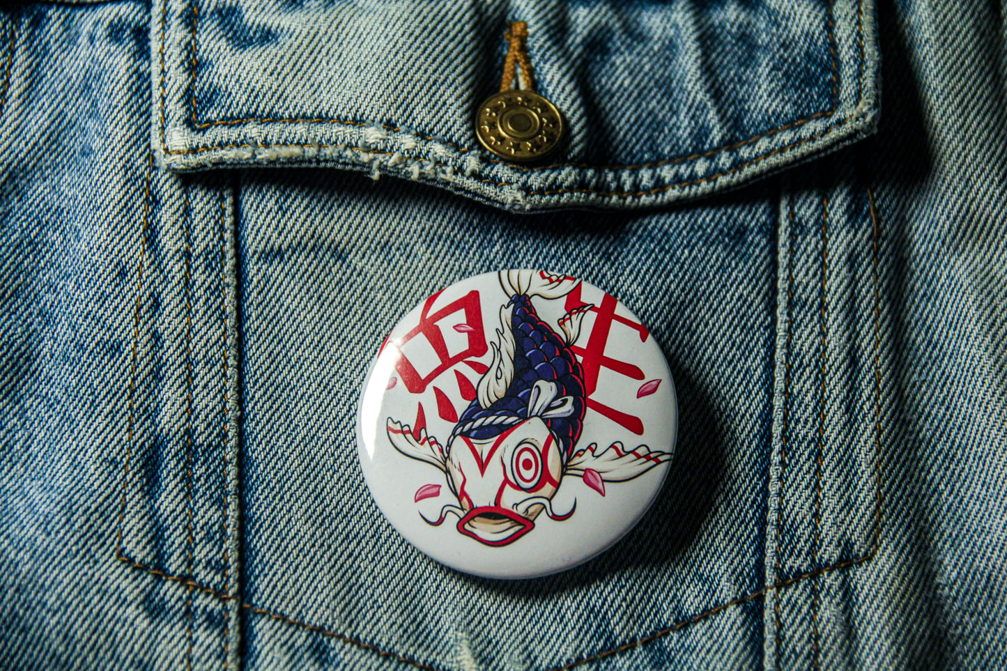 Pin's de carpe Kabuk sur une veste en jean. Fabrication artisanale. 