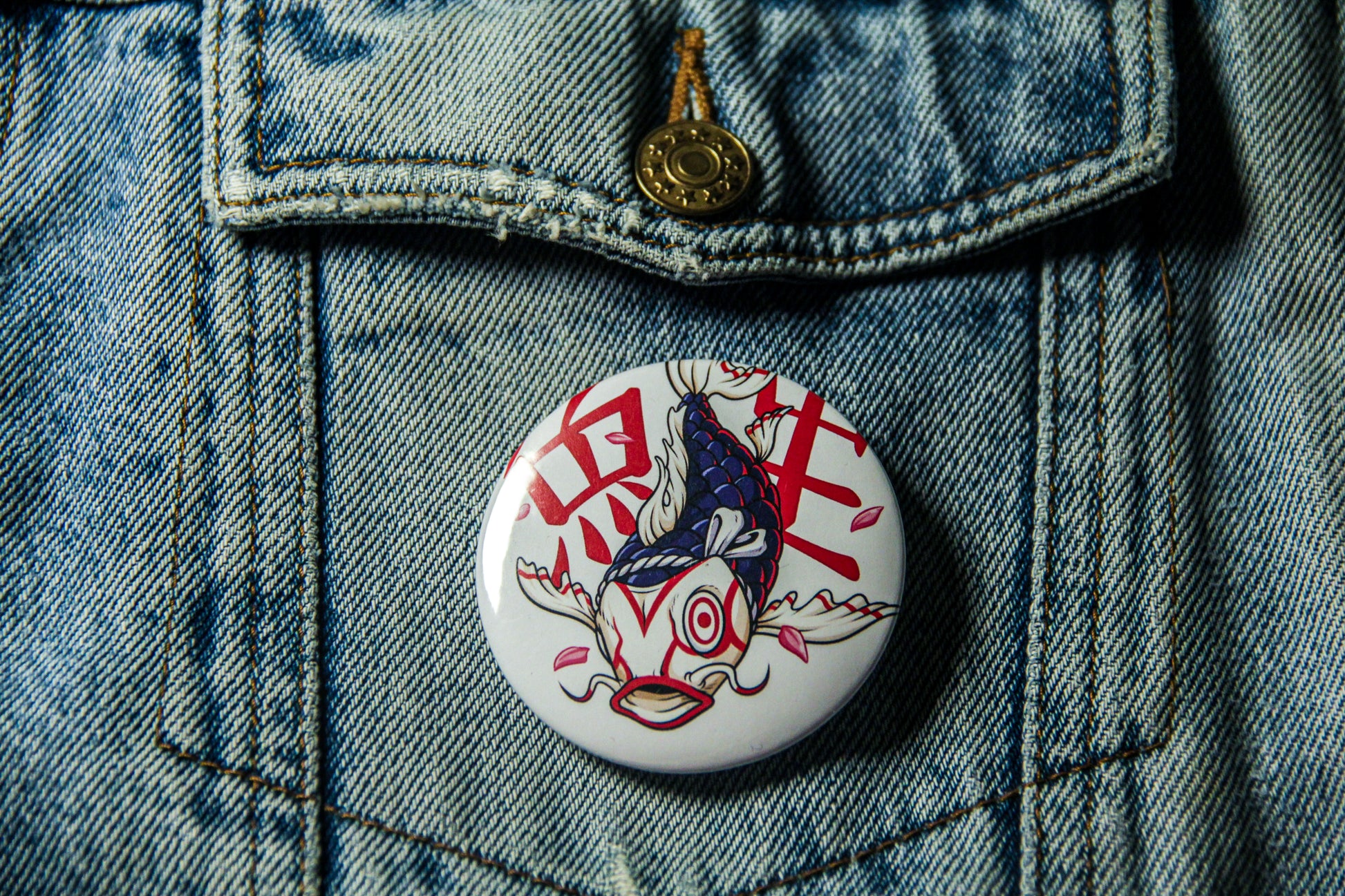 Pin's de carpe Kabuk sur une veste en jean. Fabrication artisanale. 