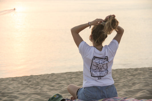 Femme de dos face à l'océan sur la du pilat; Elle porte un t shirt sérigraphié arisanalement